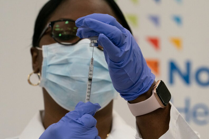Dr. Michelle Chester draws the COVID-19 vaccine into a syringe at Long Island Jewish Medical Center, in the Queens borough of New York City.