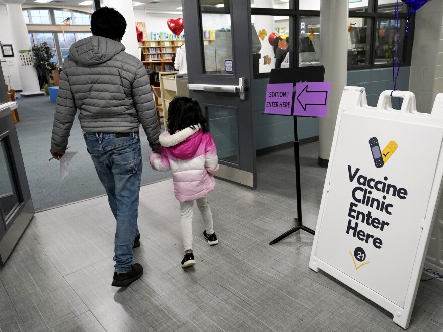 An information sign is displayed as a child arrives with her parent to receive the Pfizer COVID-19 vaccine for children 5 to 11-years-old at London Middle School in Wheeling, Ill., last month.
