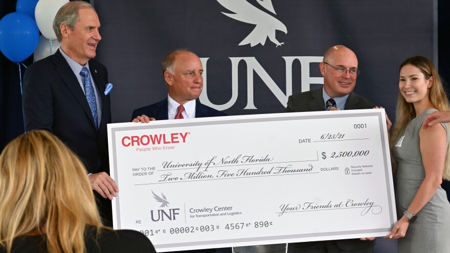 UNF President David Szymanski (left), Crowley Maritime Chairman and CEO Tom Crowley (middle) and UNF's College of Business Dean Richard Buttimer, (right) pose for photographs at the endowment's announcement ceremony on June 25, 2021.