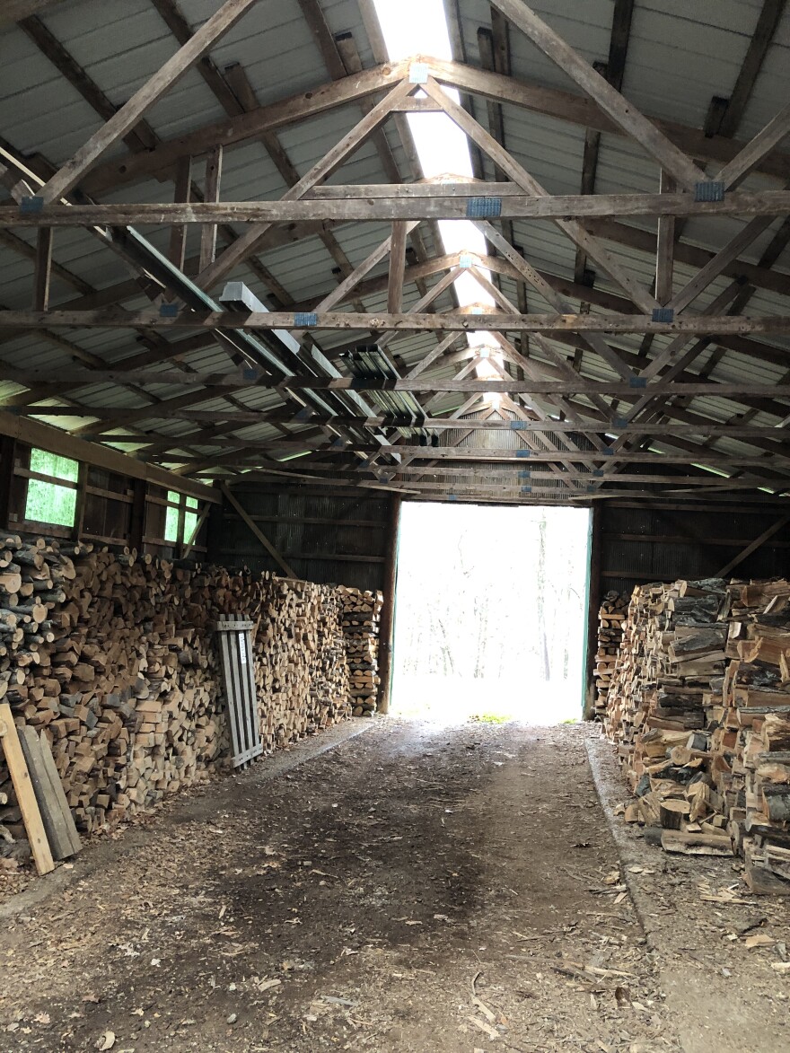 an outbuilding piled with neatly stack fire wood. Big enough to drive though, wood stacked on both sides.