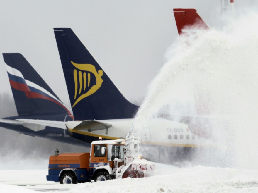 A snowblower clears snow from the airfield at Berlin's Schoenefeld airport. Germany's largest airport, in Frankfurt, has been forced to cancel hundreds of flights in recent days.