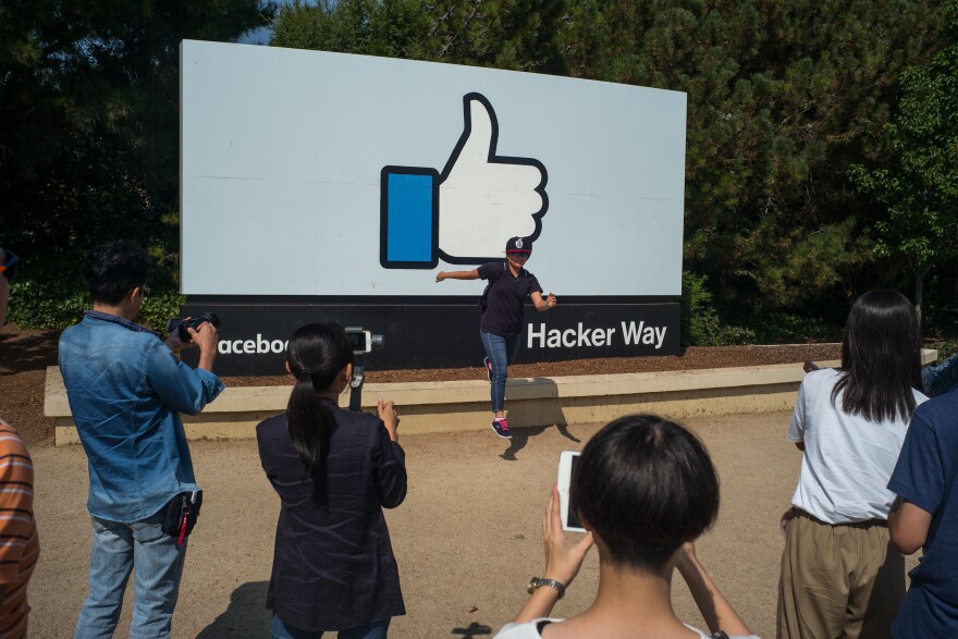 Tourists line up to take photographs in front of Facebook's "like" sign, which has become a landmark in Silicon Valley.