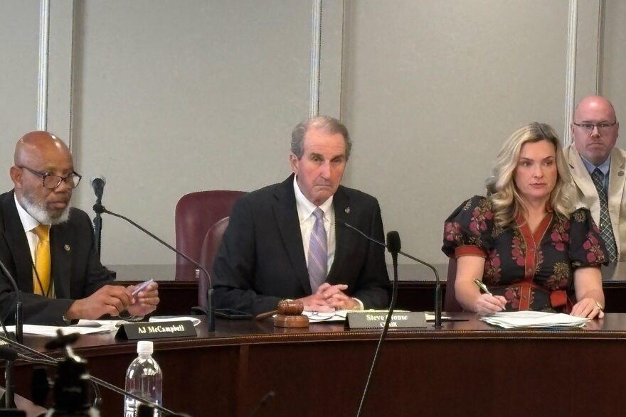 Alabama Representative Steve Clouse sits between two others at a table.