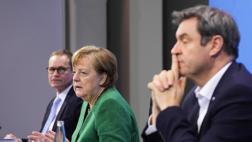 German Chancellor Angela Merkel, with Bavaria's State Premier Markus Soeder (right) and Berlin's Mayor Michael Mueller, participate in a news conference following talks via videoconference with Germany's state premiers on the extension of the current COVID-19 lockdown in Germany.