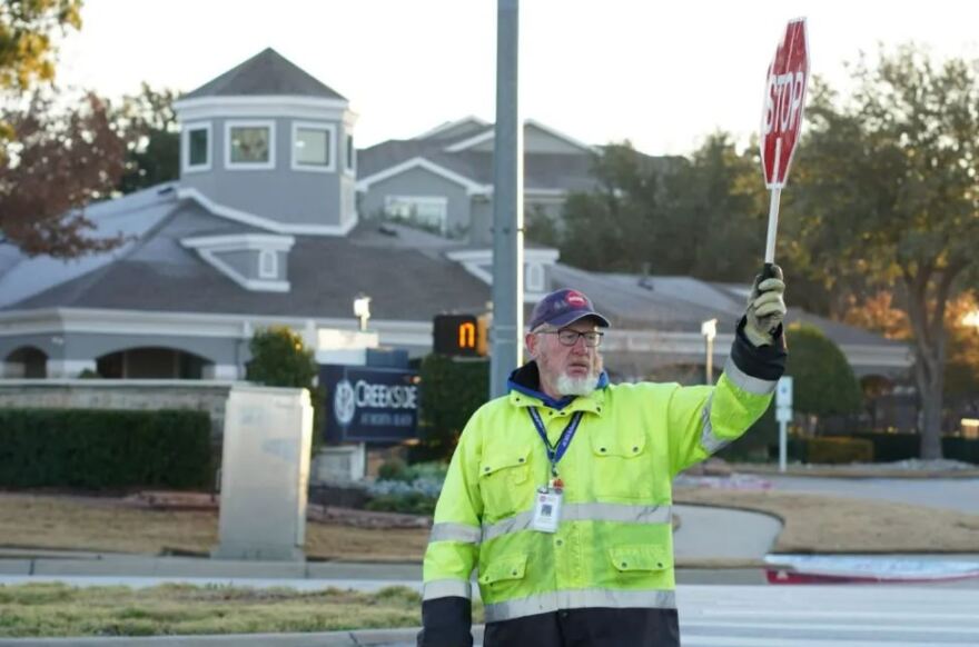 John Lyons helps Parkview Elementary School students cross the street on Monday morning, Jan. 29. He uses a stop sign and flashlight to get motorists’ attention.