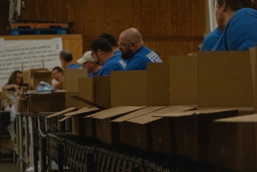 Volunteers who represent Food Lion pack boxes of food at Golden Harvest Food Bank's Aiken volunteer center.