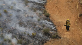 A firefighter walks along a containment line while battling a wildfire Saturday, July 28, 2018, in Redding, Calif. (Marcio Jose Sanchez/AP)