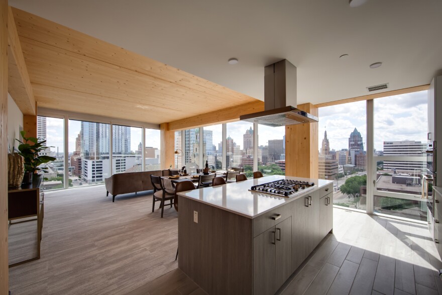 Apartments in the Ascent building in Milwaukee have exposed wood beams and ceilings, showing off the cross-laminated timber that both sequesters carbon and allows the structure to reach high-rise heights.