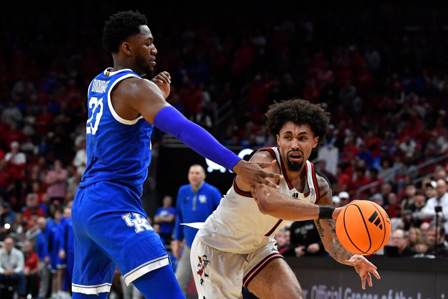 Louisville guard J'Vonne Hadley (1) passes inside away from Kentucky forward Mouhamed Dioubate (23) during the second half of an NCAA college basketball game in Louisville, Ky., Tuesday, Nov. 11, 2025. (AP Photo/Timothy D. Easley)