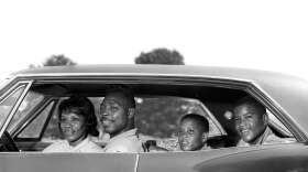 Side view of a family sitting in a four door sedan in the 1960s. (H. Armstrong Roberts/ClassicStock/Getty Images)