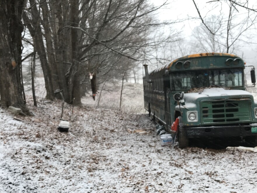 A broken down bus in a field of freshly fallen snow