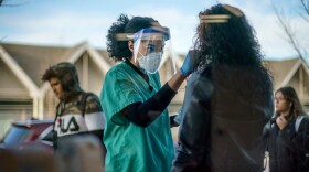 A health care worker conducts a COVID-19 test.