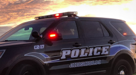 A Chisholm Police Department squad vehicle with its emergency lights engaged at dusk.