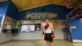 Alex Ziouras poses in front of his team's Crown Boxing Club sign.
