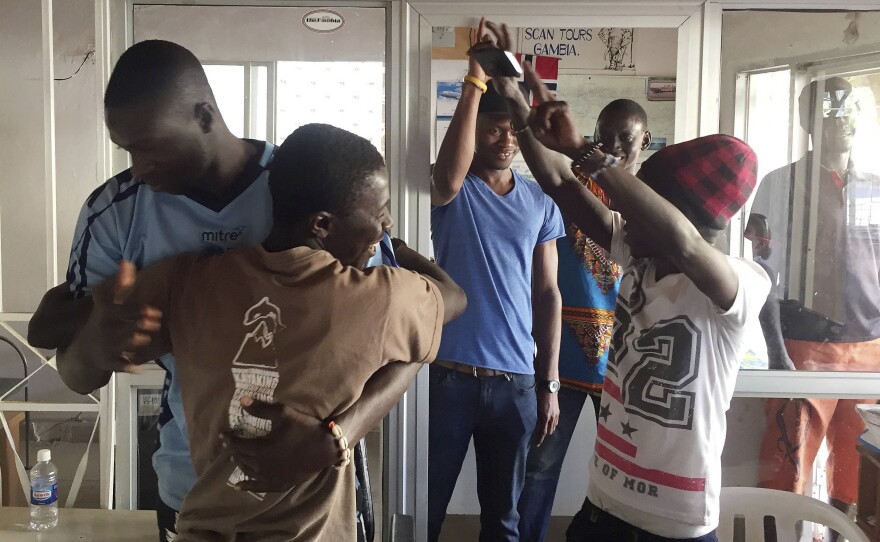 Gambians cheers in the city of Bakau on Thursday after watching a broadcast of Adama Barrow being sworn in as Gambian president at the Gambian Embassy in Dakar, Senegal.
