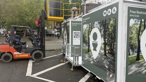 Two portable bathrooms with toilet logos on them. 