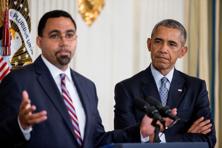 Acting Education Secretary John King Jr., left, accompanied by President Barack Obama, at the White House in Washington.