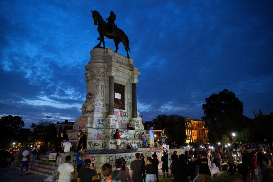 People gather around the Robert E. Lee statue on Monument Avenue in Richmond, Va., on June 4. Thursday a judge issued an indefinite injunction preventing the state from removing the statue.