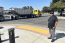 Firebaugh Mayor Freddy Valdez stands next to the intersection at Avenue 7 ½ and P Street in downtown Firebaugh on Aug. 26, 2026, as a farming truck crosses the intersection.