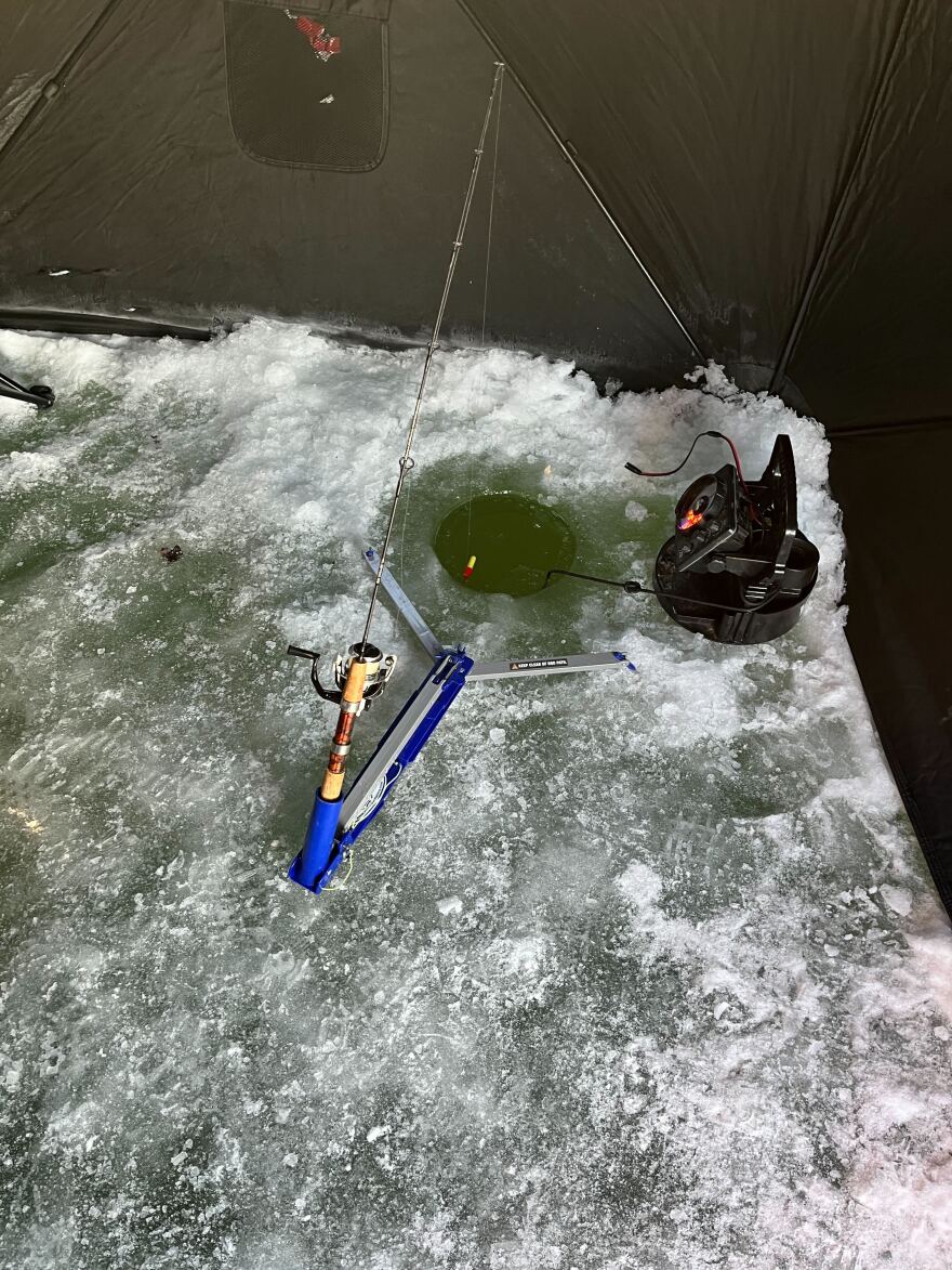 An automatice fisherman sits and waits for a bite. The fish is hooked and bells signal the capture .