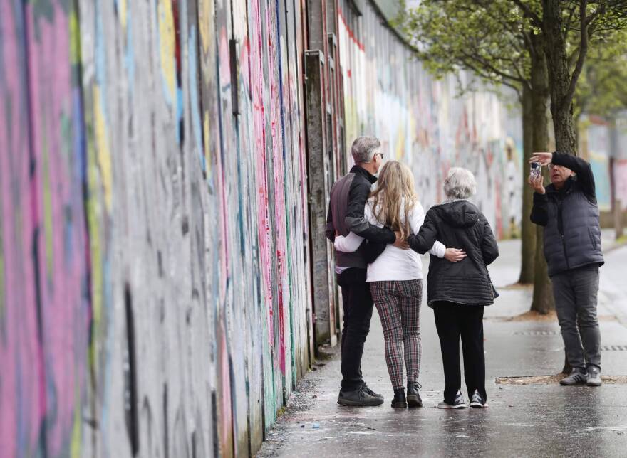 Tourists pose for a photograph next to the “peace walls” that still separate some nationalist and unionist neighborhoods in west Belfast, Northern Ireland, Wednesday, April 5, 2023. It has been 25 years since the Good Friday Agreement largely ended a conflict in Northern Ireland that left 3,600 people dead. (Peter Morrison/AP)