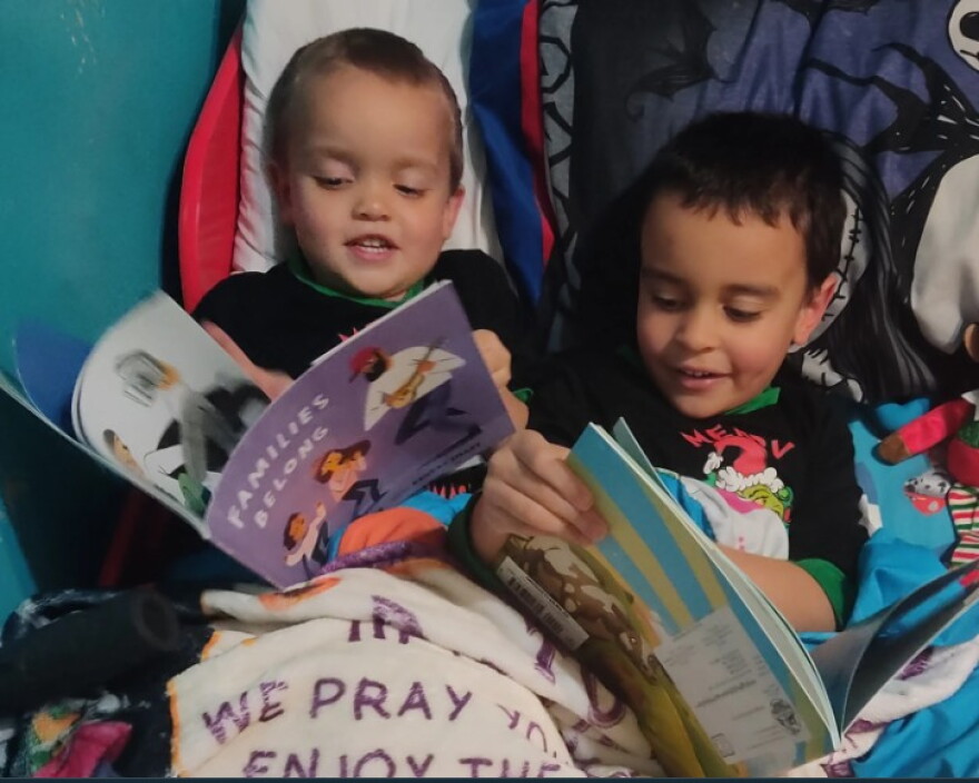 Ashley McNair's sons Kenny Jr., then 3, and Matteo, then 5, read books they received from the Rochester Imagination Library in this 2022 file photo.