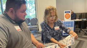 Juan Lopez and Susan Ugell check out their family description in the Cost of Poverty Experience.