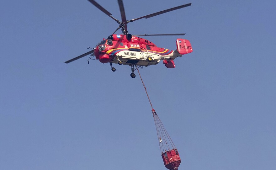 In this photo released by Xinhua News Agency, a helicopter leaves to fight a forest fire in China's Sichuan Province.