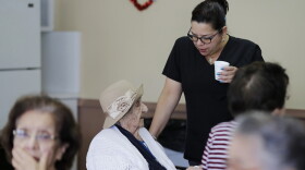 In this March 4, 2020, photo, Juana Romero, left, talks with nursing assistant Dulce Torres, right, at Little Havana Activities and Nutrition Centers of Dade County, Inc., in Miami. The new coronavirus is posing a special challenge for nursing homes and other facilities that provide care for the elderly. (AP Photo/Brynn Anderson)
