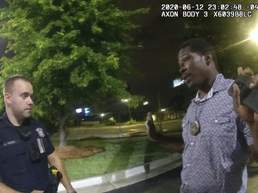 In a screenshot from body camera video provided by the Atlanta Police Department, Rayshard Brooks speaks with Officer Garrett Rolfe in a Wendy's parking lot.