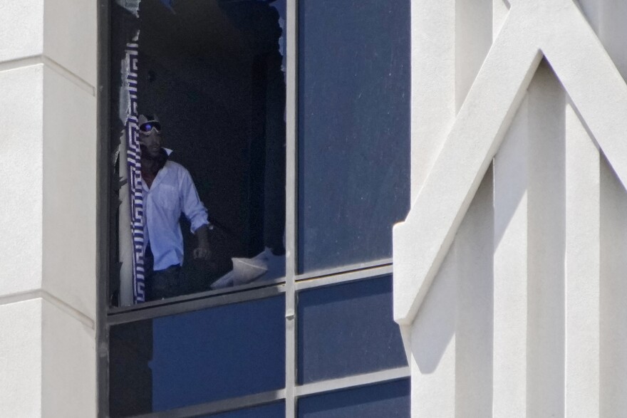A person looks out a broken window on a hotel tower at Caesars Palace hotel-casino, Tuesday, July 11, 2023, in Las Vegas.