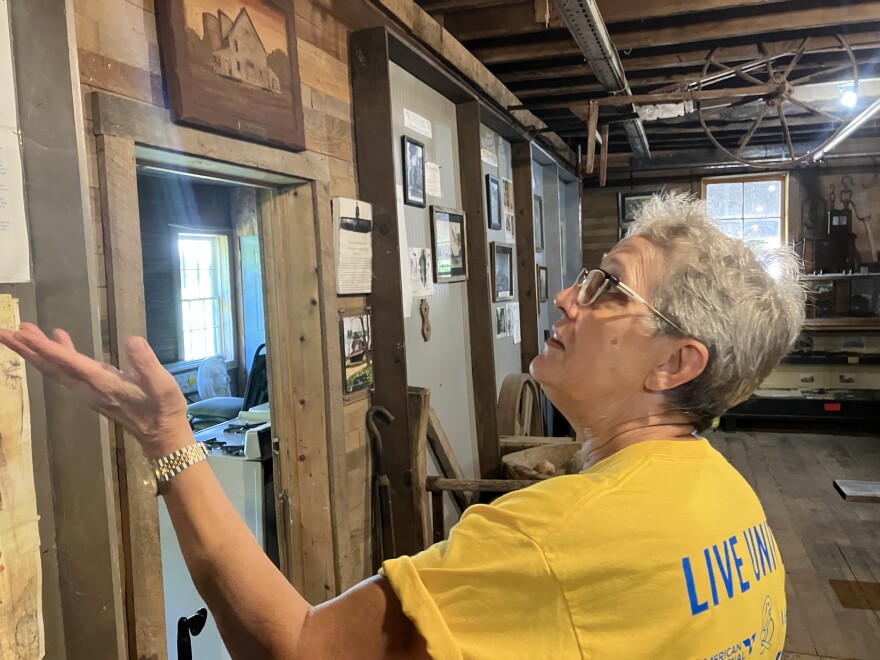 Fair Grove Historical & Preservation Society president Mary Terry shows an Ozarks Public Radio reporter around the 141-year-old Wommack Mill, restored since the late 1970s and filled with historic artifacts.
