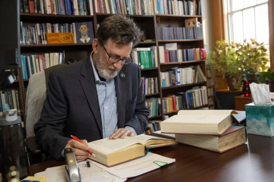 Jerry Telmen, a contracts professor at Oklahoma City University School of Law, browses a text in his office on July 7, 2026.
