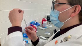 A technician from the Findlay College of Pharmacy fills a syringe with a dose of the Pfizer vaccine at a clinic in Reynoldsburg in February 2021.
