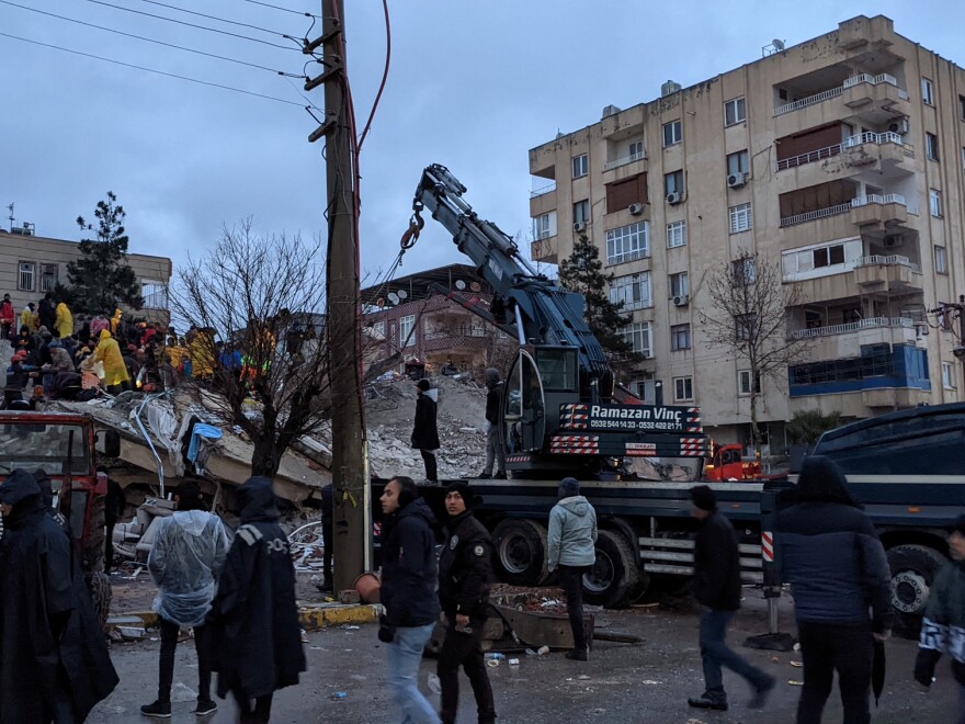 Rescue workers and volunteers search for survivors in the rubble of a collapsed building, in Sanliurfa, Turkey, on Monday.