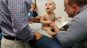 One year old Eleanor holds the new book she received from Dr. David Tayloe during her check up. The New Bern clinic gives books to kids at each of their well visits from six months to five years of age, as part of the Reach Out And Read program.