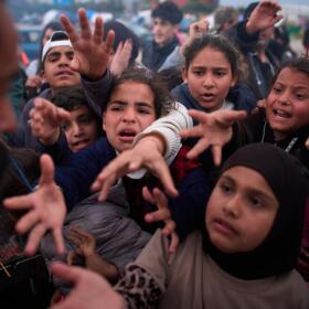 Displaced families extend their hands while waiting for donated food beside the tents they use as shelters after fleeing Israeli bombardment in southern Lebanon, in Beirut, Lebanon, Thursday, April 9, 2026. (Emilio Morenatti/AP)