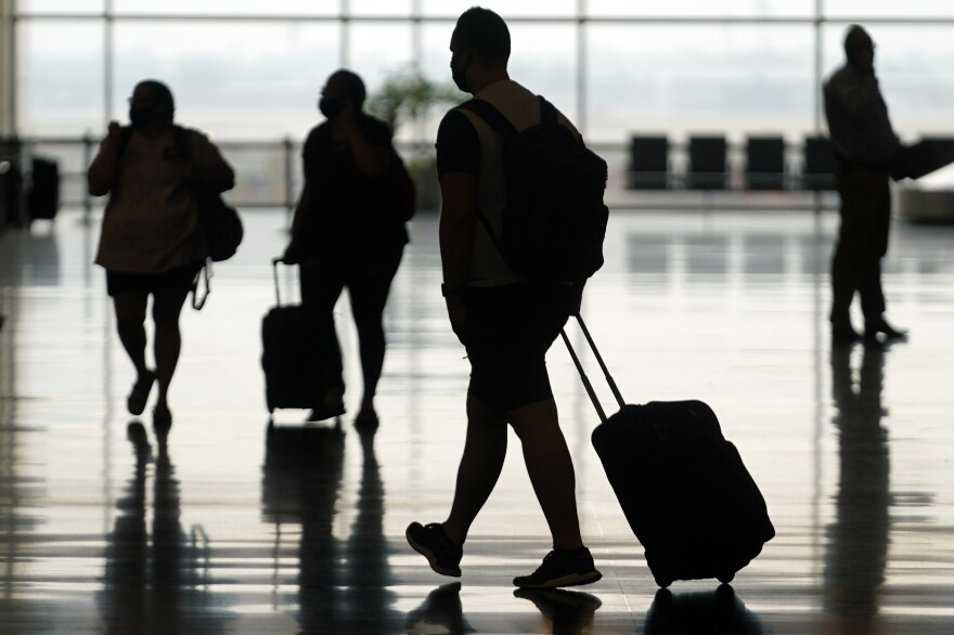 Travelers move through Salt Lake City International Airport on Aug. 17, 2021. The Federal Aviation Administration said Friday that it's seeking record civil fines against two passengers who assaulted other people on flights last summer.