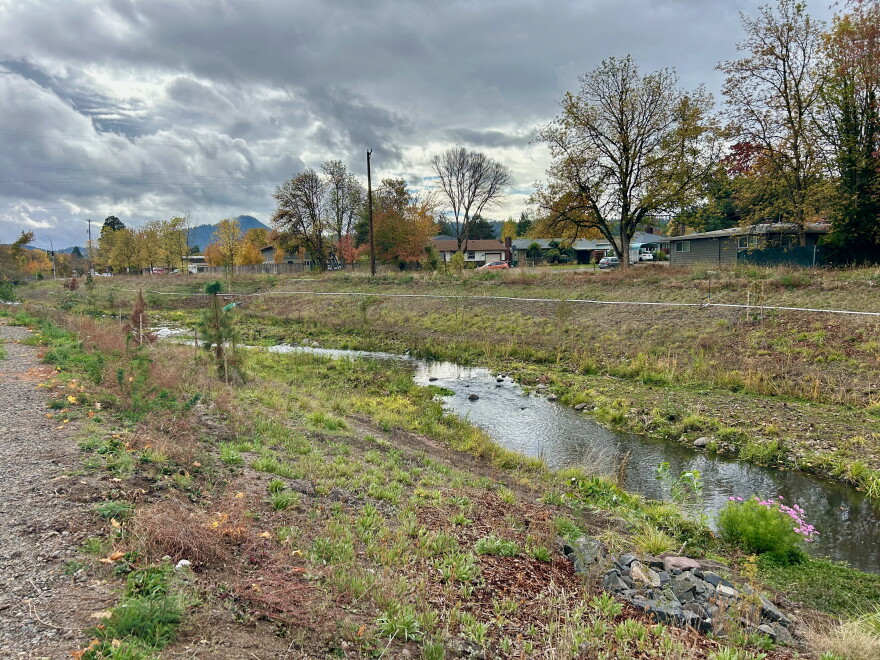 A stream runs between a bike path and a street
