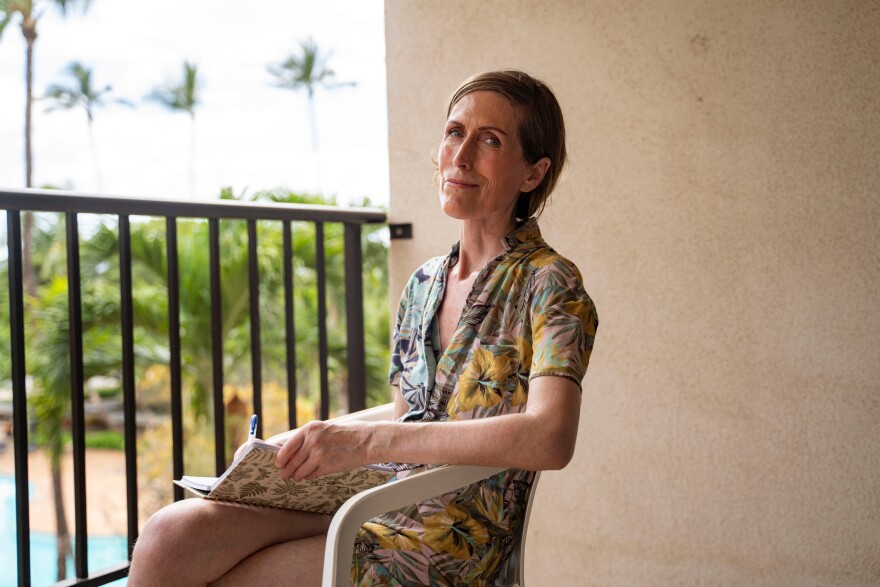 Mari Younger poses for a portrait on the balcony of her converted hotel room where she lives after being displaced by the Maui fires two years prior, in Kihei, Hawaiʻi, Wednesday, March 4, 2026. (AP Photo/Mengshin Lin)