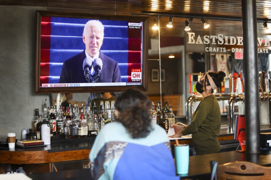 Assistant manager Sarah Espinosa (right) and her friend, Taylor Malray, watch Joe Biden's inauguration as EastSide Tavern opens for the day.