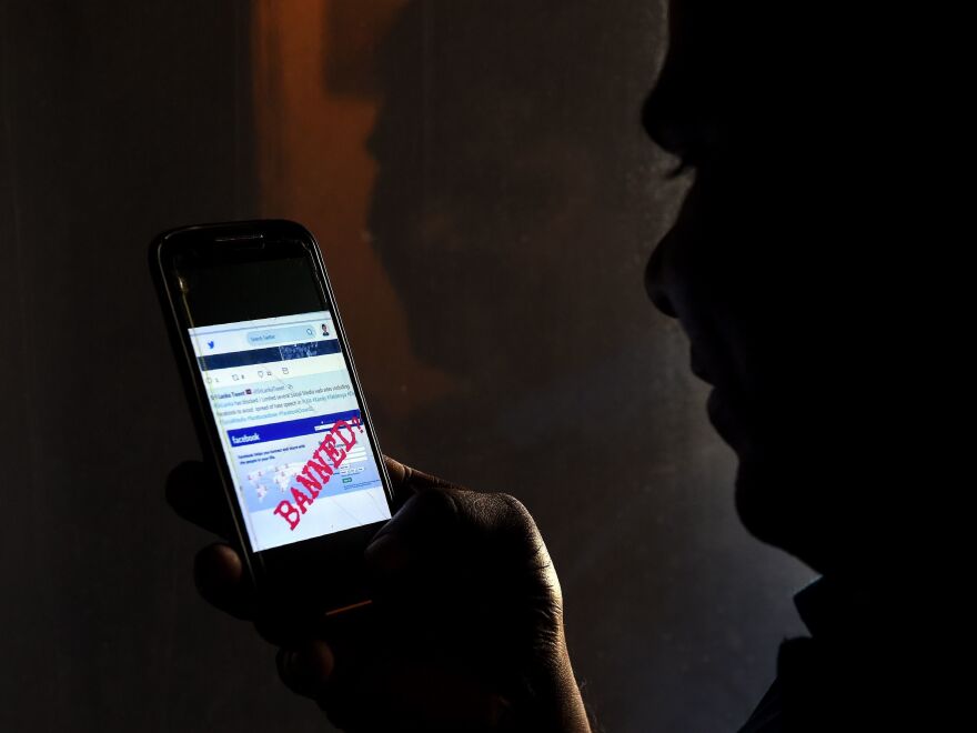 A Sri Lankan mobile phone user on Wednesday holds up a Twitter message indicating that Facebook has been banned in the capital, Colombo.