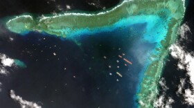 Overview of Whitsun Reef in the South China Sea and Chinese vessels moored in the waters surrounding the boomerang-shaped coral reef on March 23.
