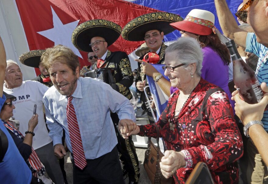 Cuban-American Miguel Saavedra, left, dances to the music of a mariachi group as they celebrate, Friday, Jan. 20, 2017, in the Little Havana area in Miami, before President-elect Donald Trump is sworn in as the 45th president of the United States. (AP Photo/Alan Diaz)