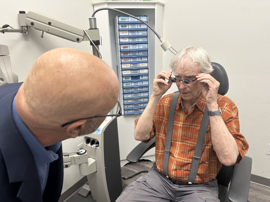 Dr. Andrew Bock checks the specialized glasses worn by Julian Dean of Santa Barbara.