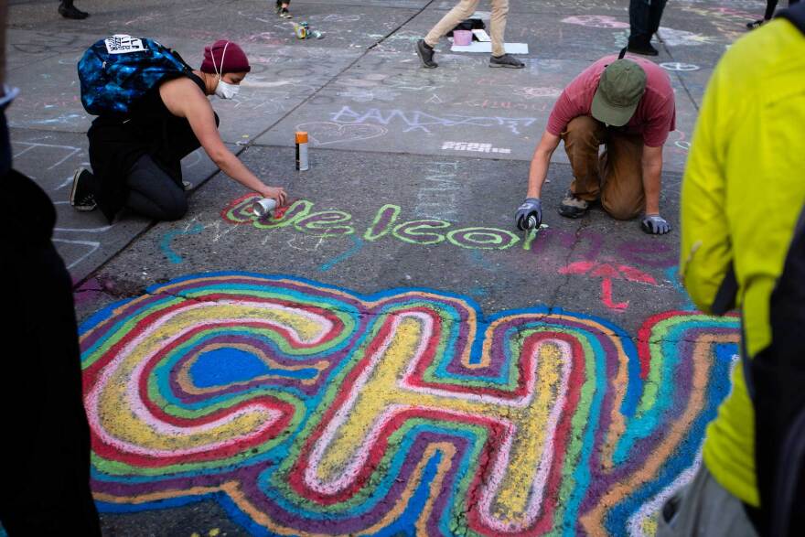 Protesters draw on the streets inside the CHAZ. On Wednesday, they began painting "Black Lives Matter" on the street, similar to murals seen in other cities across the country.