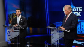 Republican nominee for U.S. Senate Mike Rogers, right, faces off against Democratic nominee for U.S. Senate Abdul El-Sayed on a debate stage at podiums.