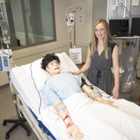  WSU Spokane College of Nursing assistant dean for research Lois James poses beside the lab mannequin that tired nurses interacted with in a recent study.