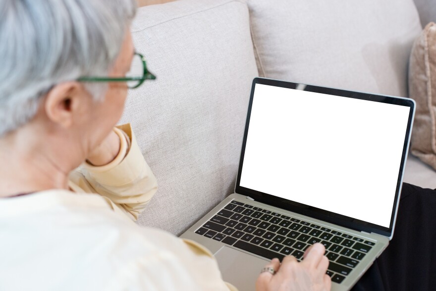 This stock image shows a female senior citizen using a laptop computer.