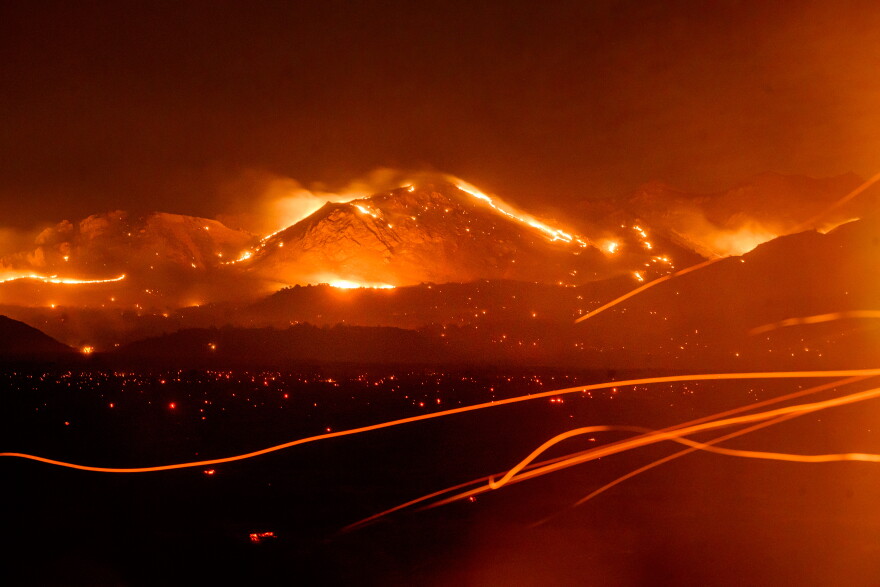 Seen in a long exposure, the Bug Fire burns near Doyle in unincorporated Lassen County, Calif., on Thursday, Aug. 13, 2026. (AP Photo/Noah Berger)